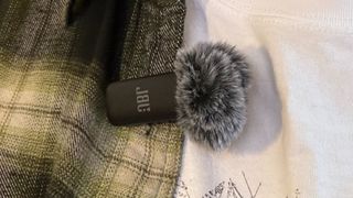 The JBL Quantum Stream Wireless mic attached to clothing.